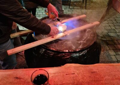 Feuerzangenbowle an der Hexenhütte: Rum wird über den brennenden Zuckerhut über dem Hexenkessel gegossen