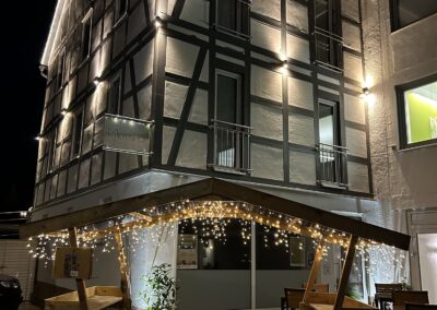 Die Hexenhütte abends mit Lichterketten vor dem beleuchteten Fachwerkhaus des Meyenhof